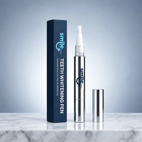 Smile Dew peroxide-free teeth whitening pen with exposed brush tip, silver cap and navy box on a marble surface.