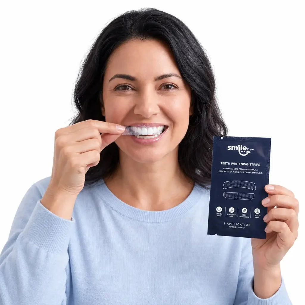 Woman applying Smile Dew teeth whitening strips to her upper teeth while holding the branded sachet.